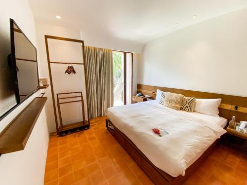 Hotel Lumi Gili Trawangan في غيلي تراوانغان: غرفة نوم بسرير ونافذة كبيرة