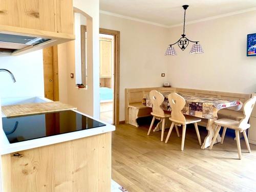 a kitchen and dining room with a table and chairs at EMARGHE, CASA A MOENA in Moena