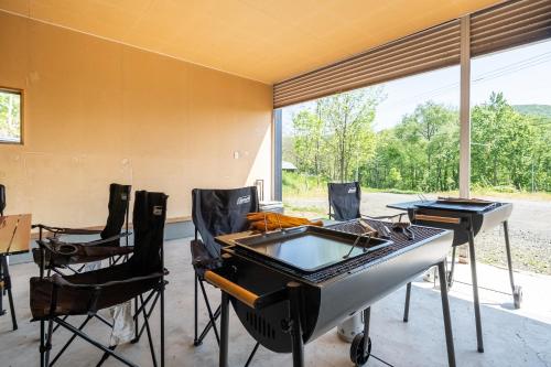 a room with a ping pong table and chairs at The Landmark in Furano