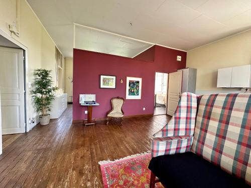 a living room with a couch and a red wall at Villa Vallière bed&breakfast in Vallières