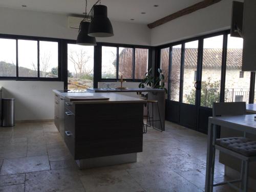 - une cuisine avec de grandes fenêtres et un grand îlot dans l'établissement Mas provençal dans un lieu exceptionnel, à Bollène