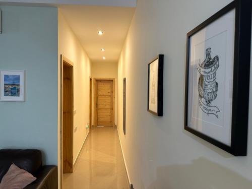 a hallway with white walls and a picture on the wall at Ewa Apt - 3-Bedrooms Apt near Sliema - St Julians Seafront in Il-Gżira