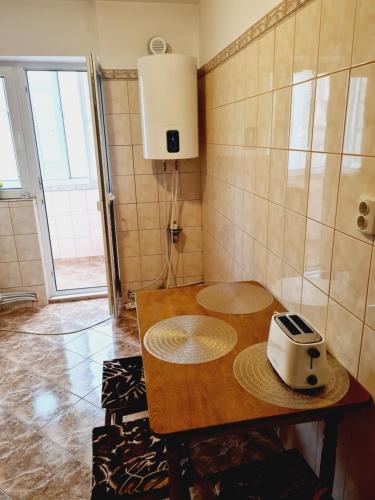 a kitchen with a table with a toaster on it at Apartament Slănic Prahova in Slănic