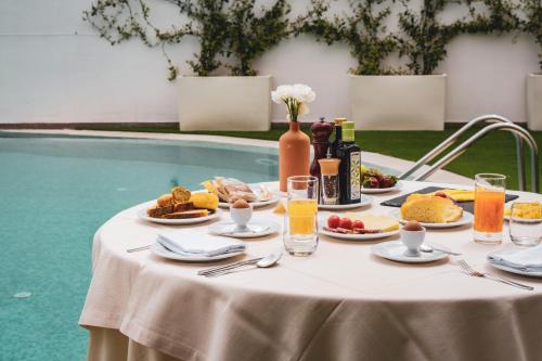 アルベロベッロにあるHotel Majesty Alberobelloのプールサイドのテーブル(飲食付)