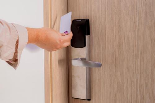 a person holding a piece of paper in a door handle at Hotel Marco Polo Rodadero in Santa Marta