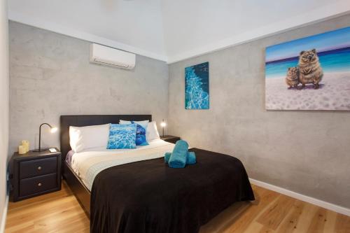a bedroom with a bed and a painting on the wall at Binks Beach House - South Fremantle in South Fremantle