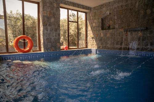 nbz chalet Jasmine stairs في Al ‘Aqar: حمام سباحة مع منقذ للحياة في غرفة بها نوافذ