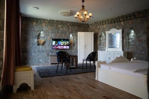 a bedroom with a bed and a desk and chairs at nbz chalet Jasmine stairs in Al ‘Aqar