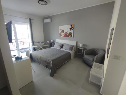 a bedroom with a bed and a couch and a window at B&B La Finestra sul Mare in Milazzo