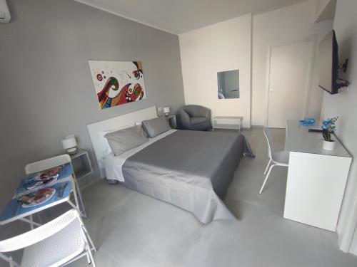 a small white bedroom with a bed and a desk at B&B La Finestra sul Mare in Milazzo