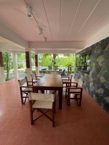 a dining room with a wooden table and chairs at Villa Aisawan in Phuket