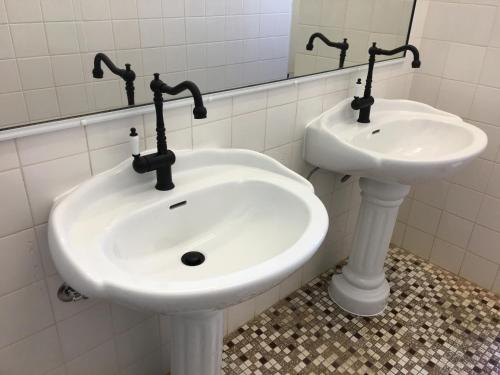 y baño con lavabo blanco y espejo. en HISTORIC STAR LODGE and STATION MASTERS HOUSE NARRANDERA en Narrandera