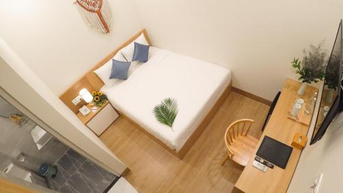 a small room with a bed and a table at Vy's House Phanthiet Hotel in Ấp Tân An (1)