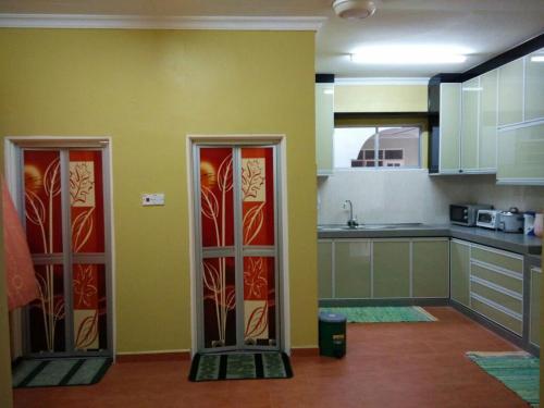 a kitchen with two glass doors in a room at Wafi Guesthouse in Kuala Terengganu