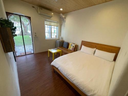 a bedroom with a white bed and a window at 愛玩生活墾丁聚所 in Nanwan