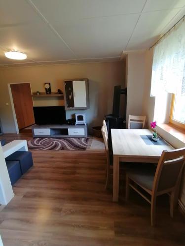 a living room with a table and a dining room at Rekreační chata Menfis in Hořice na Šumavě