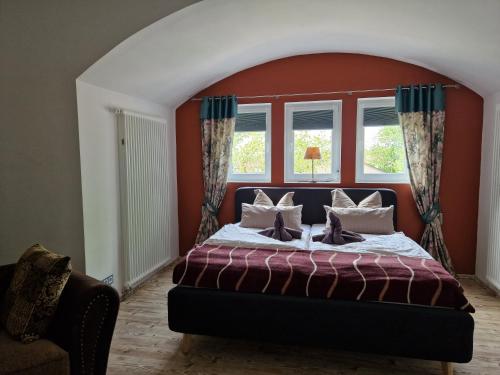 Gästehaus Villa Reich في لوبين: غرفة نوم بسرير بجدار احمر