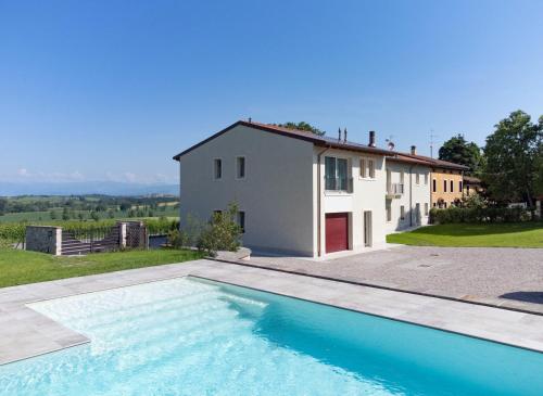 a villa with a swimming pool in front of a house at RipassoQui in Custoza