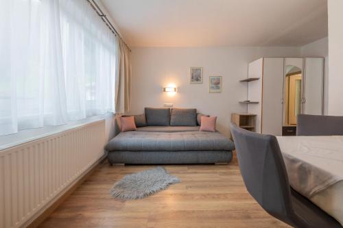 a living room with a couch and a window at Pension Steinadler in Neustift im Stubaital