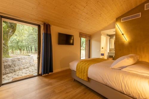 a bedroom with a bed and a large window at Cantu di Fiumu in Zonza