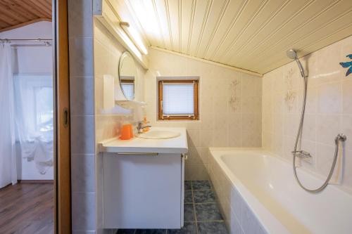 ein Badezimmer mit einem Waschbecken, einer Badewanne und einer Dusche in der Unterkunft Pension Steinadler in Neustift im Stubaital