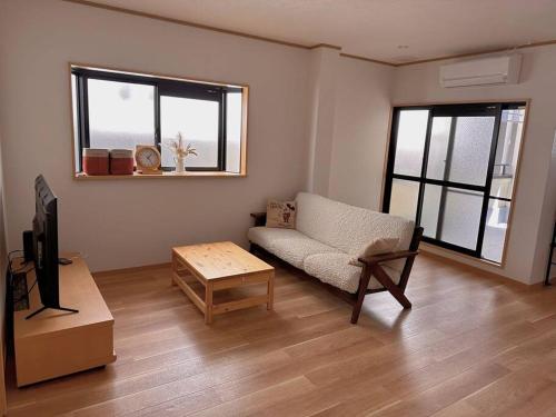 a living room with a couch and a coffee table at COZY ROOM 三丁目〜難波日本橋駅奈良駅直通/6人まで/商店街近く～60㎡快適空間～ in Osaka