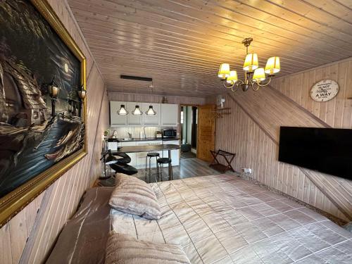 a living room with a chandelier and a kitchen at Koivula Guest House in Kotka