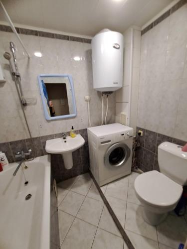 a bathroom with a toilet sink and a washing machine at 2-х комнатная Квартира возле Солнечной галлереи in Yekaterinovka