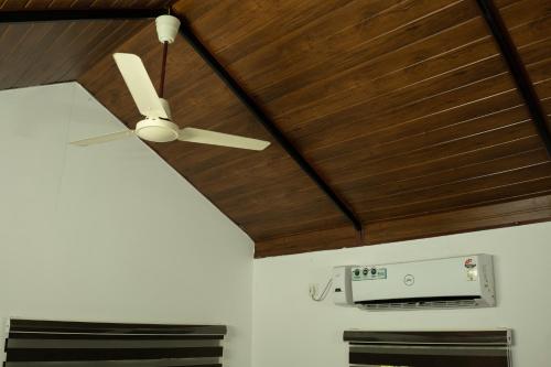 a ceiling fan hanging from a wooden ceiling at The Nest Thattekad in Thattakād