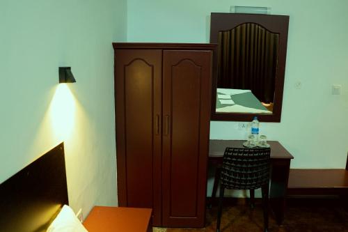 a bedroom with a cabinet and a table and a mirror at The Nest Thattekad in Thattakād