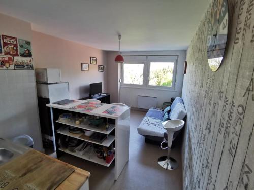 ein kleines Zimmer mit einem Sofa und einem Tisch in der Unterkunft STUDIO HAUTEUR GERARDMER in Gérardmer