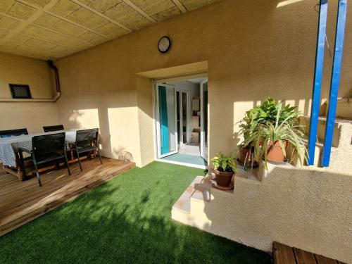 un salon avec de l'herbe verte et un balcon dans l'établissement Chez Marie, à Bessan