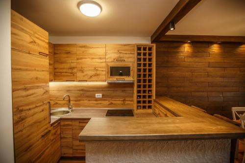 una cucina con pareti in legno, lavandino e forno a microonde di Montagna Resort a Žabljak