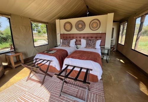 a bedroom with two beds in a tent at Die Boskamp in Marble Hall