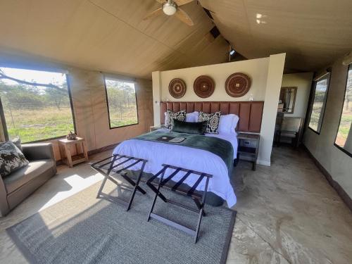 a bedroom with a bed and two chairs in it at Die Boskamp Self-Catering Bush Retreat in Marble Hall