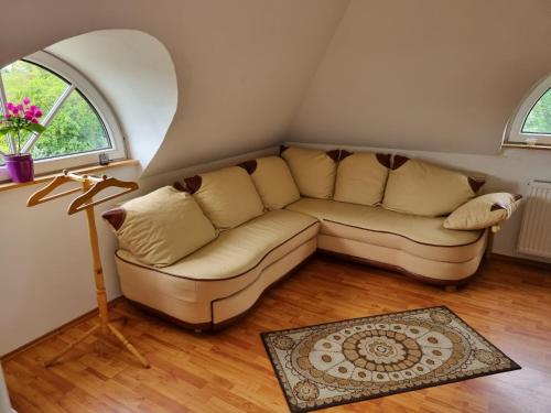 a living room with a couch and a window at Jurta Hotel Balatongyörök in Balatongyörök