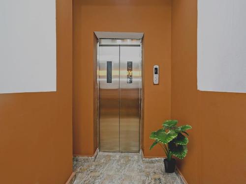 a hallway with an elevator and a potted plant at FabHotel Seven Inn in Bhubaneshwar