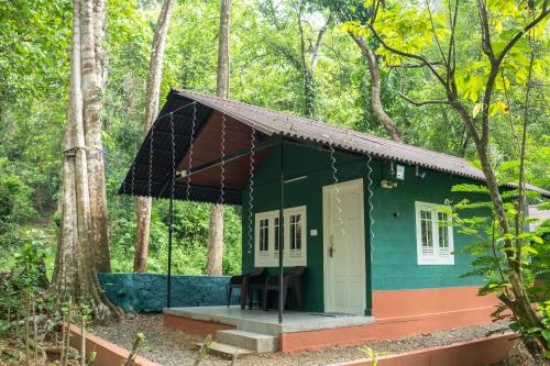 a small green house in the middle of a forest at The Nest Thattekad in Thattakād