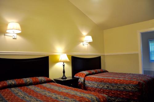 ein Hotelzimmer mit 2 Betten und 2 Lampen in der Unterkunft Countryside Motel in Fishkill