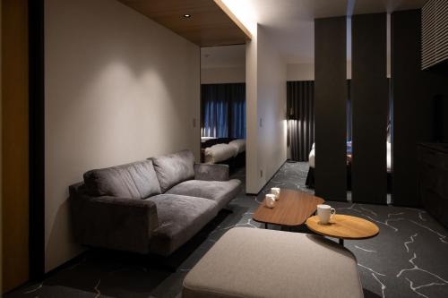 ein Wohnzimmer mit einem Sofa und einem Tisch in der Unterkunft Hotel Liberte Kyoto Gojo in Kyoto
