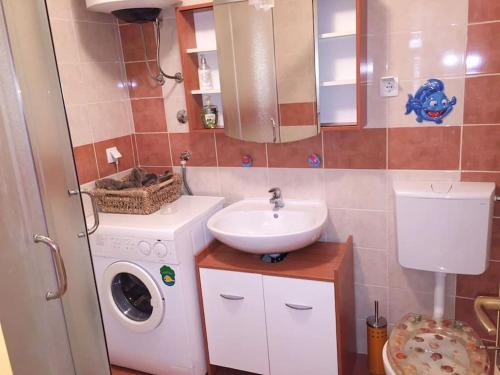 ein Badezimmer mit Waschbecken und Waschmaschine in der Unterkunft Spektar - Three-bedroom House with Grill in City Center in Novalja