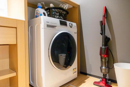 a washing machine in a kitchen with a vacuum at Hotel Liberte Kyoto Gojo in Kyoto