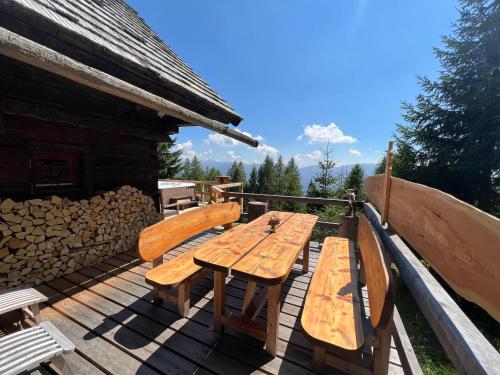 a wooden table and benches on a deck at Almhütte Kärnten in Maltaberg