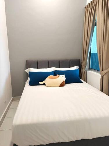 Una cama con dos almohadas azules y un animal de peluche. en W45WarmStay@GoldenHillsNightMarket en Brinchang