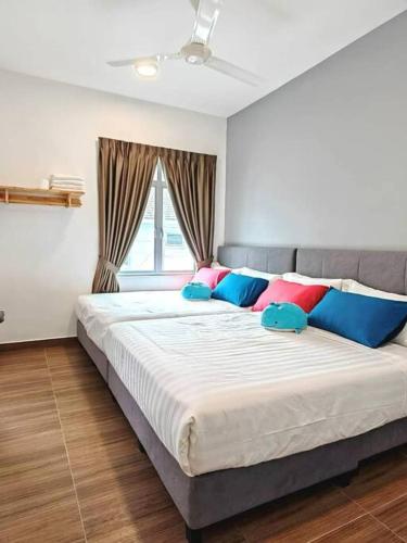 sypialnia z dużym łóżkiem z kolorowymi poduszkami w obiekcie W45WarmStay@GoldenHillsNightMarket w mieście Brinchang