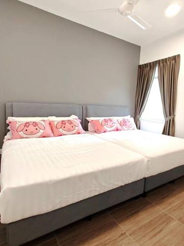 1 dormitorio con 1 cama grande con almohadas rosas en W45WarmStay@GoldenHillsNightMarket, en Brinchang