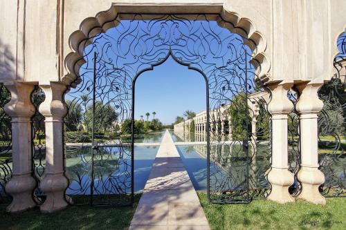a gate in a building with a reflection in the water at Palais Namaskar in Marrakech