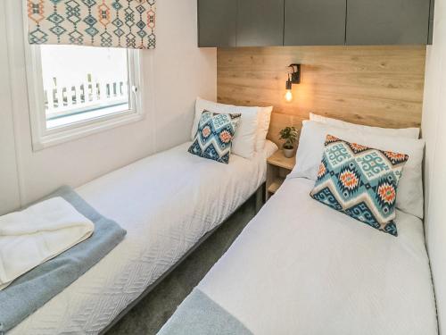 Duas camas num pequeno quarto com uma janela em Long View Lodge em Felton