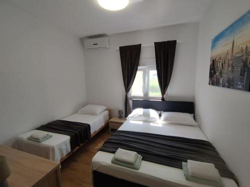 a hotel room with two beds and a window at Apartment Bella Costa II. in Kaštela