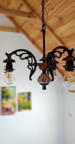 a black chandelier hanging from a ceiling at Вуличок in Kamianets-Podilskyi